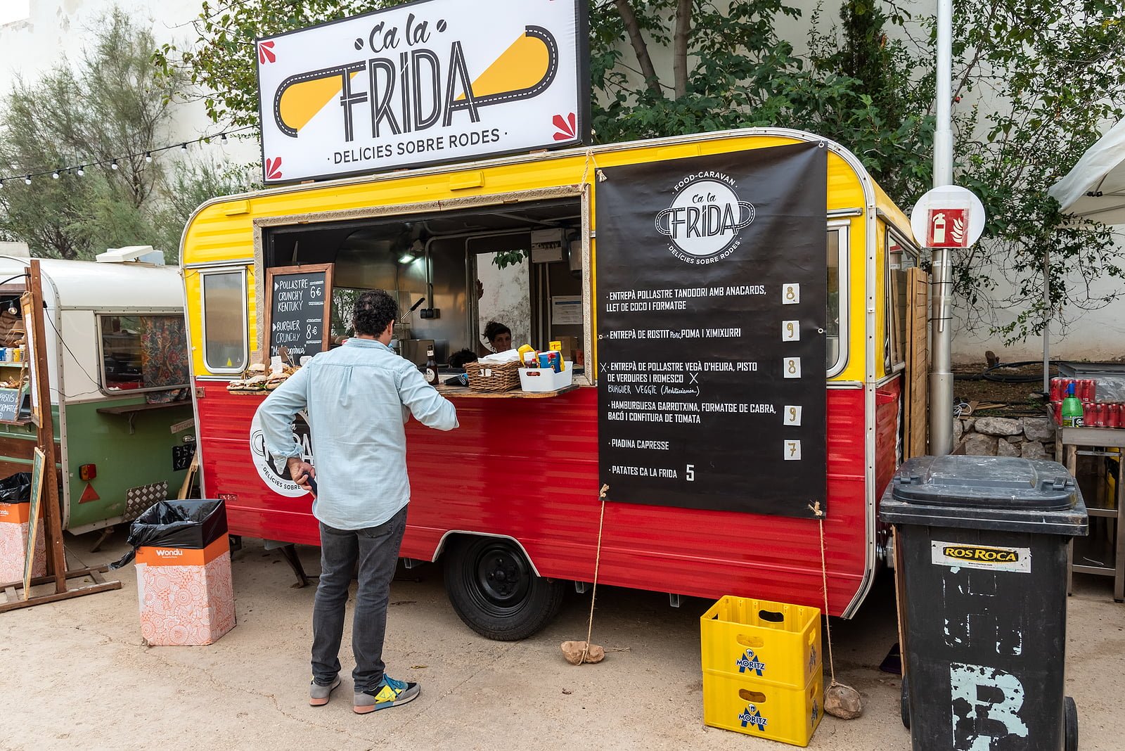 Sitges, Barcelona, Spain - October 08, 2022: Customer waiting to be served in a caravan adapted for the sale of fast food on the street